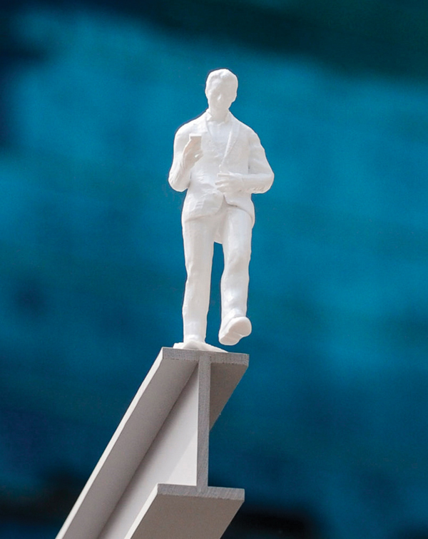 Closeup of a figurine of a man standing on Sintra® graphic display board 