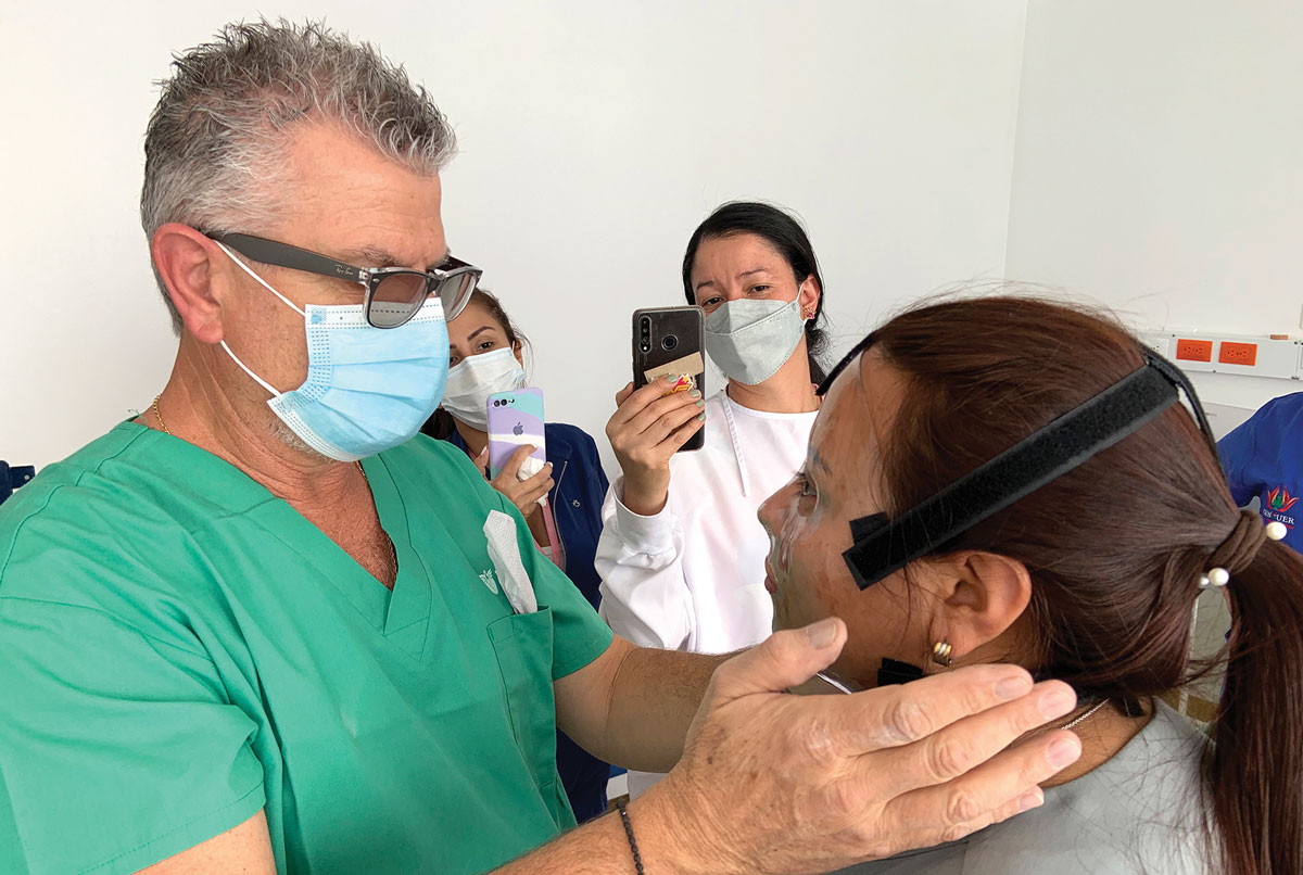 Physicians for Peace volunteer therapist Michael Serghiou is explaining how to put the mask on the patient and how to check if the mask is applying the right amount of pressure so that the scars remain flat during the healing process