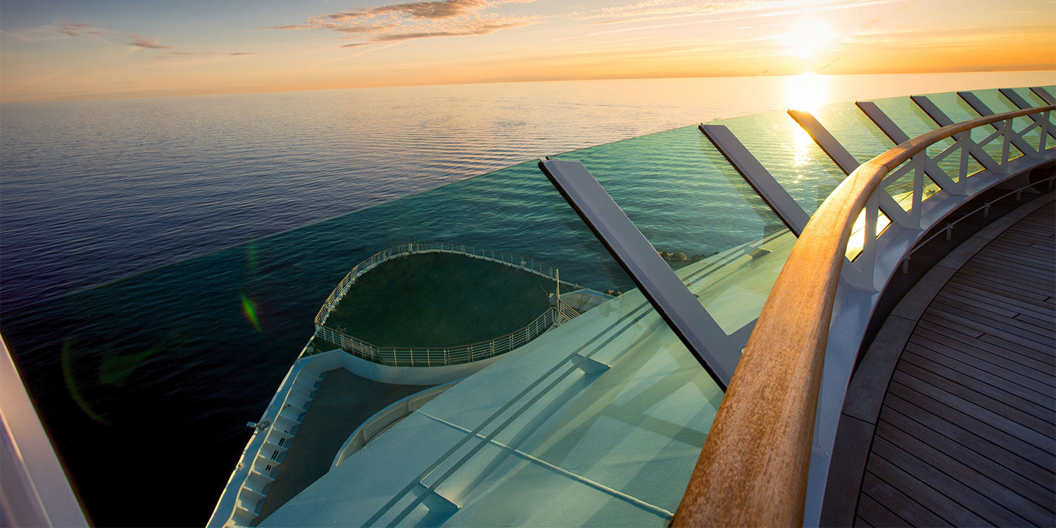 View of ocean from balcony of cruise ship during sunset