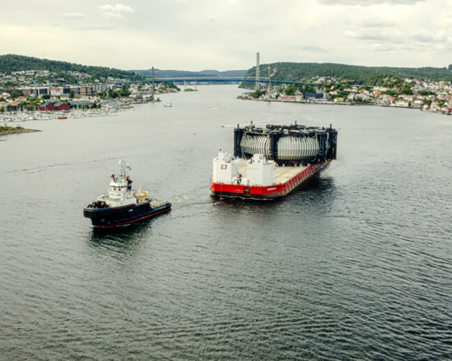 the Marine Donut held by a large barge while on its way to a deployment site