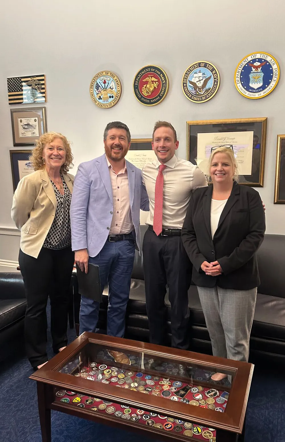 Karen Brock-Amoah, Chris Corona, Susan Avery, and Max Miller posing for a group photo surrounded by military memorabilia