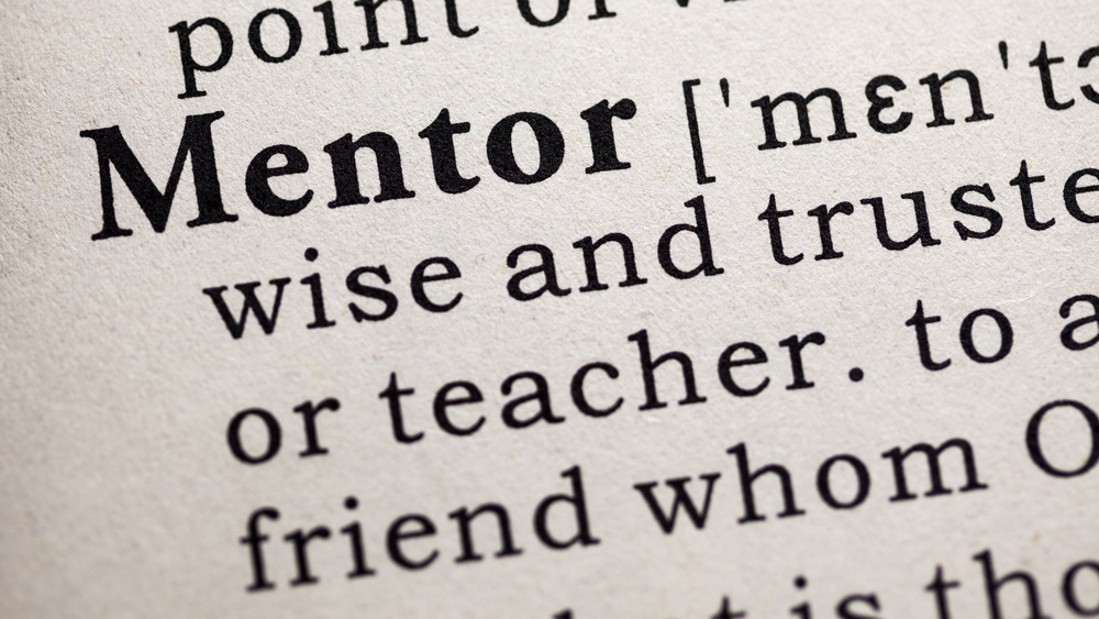 closeup of definition of "mentor" displayed in a dictionary
