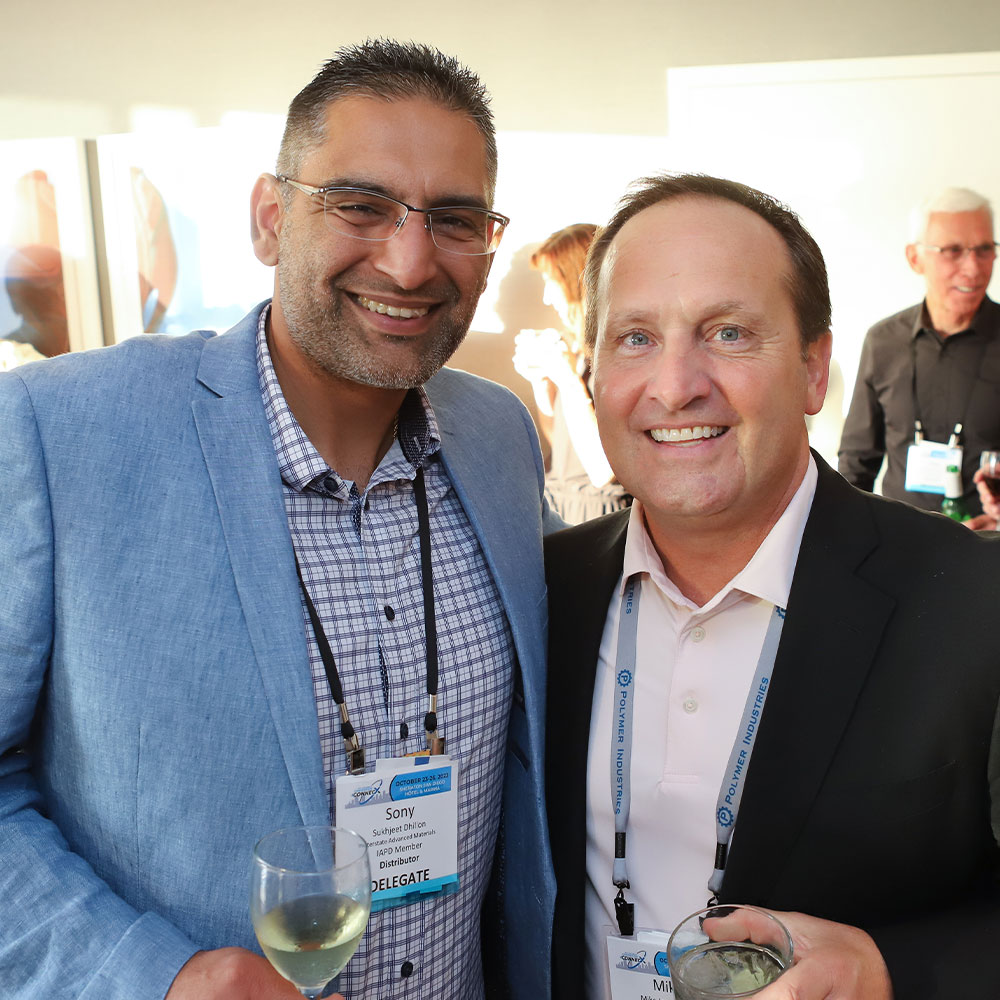 two male delegates take a photo together during social hour