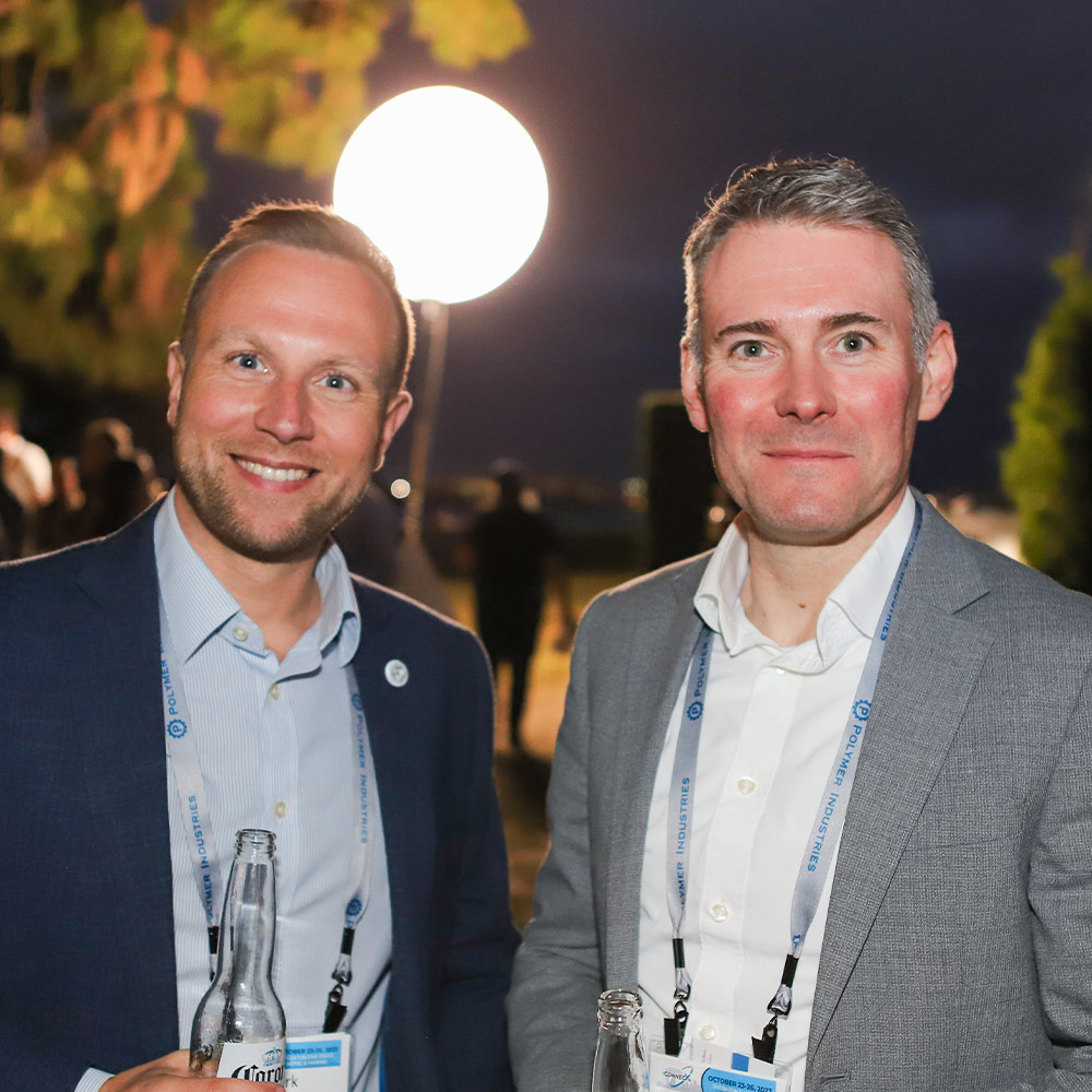 male attendees stand side by side for a photo at an evening convention event