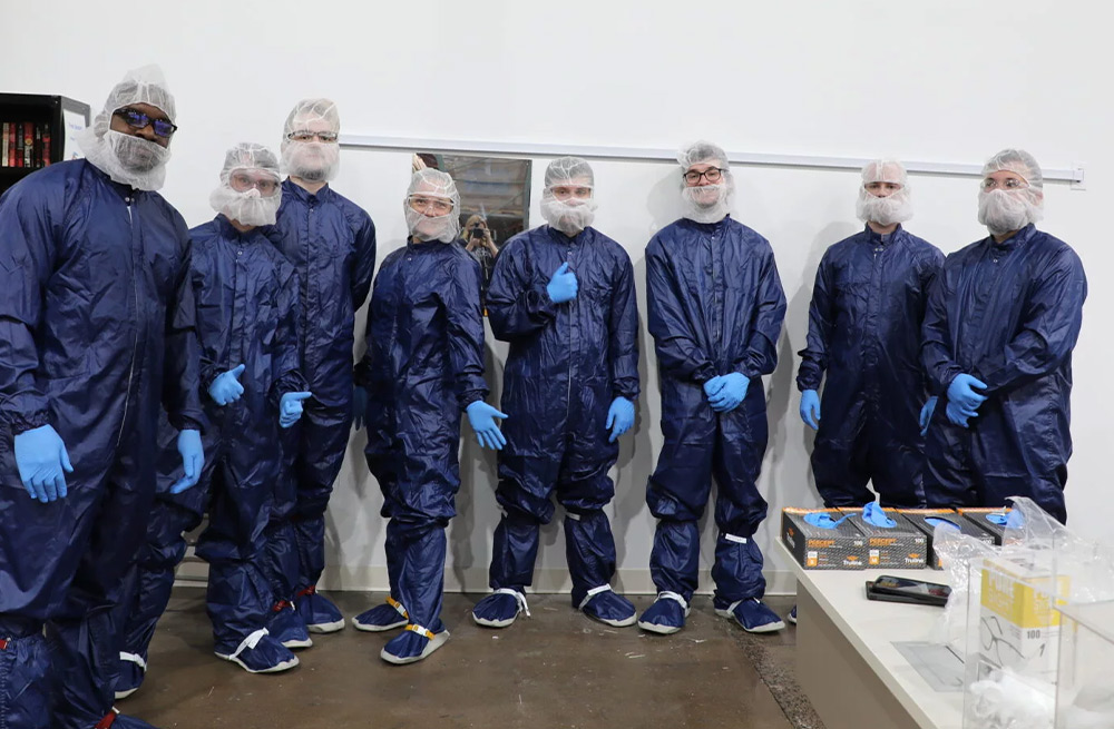 students gear up in blue plastic suits and hair-net face masks to visit NewAge Industries, Inc. on Manufacturing Day in 2023