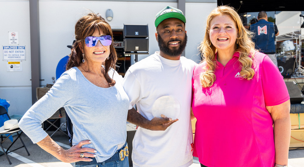 employee Jaquan is pictured with A&C Plastics CEO Carolyn Faulk (left) and President Katie Clapp (right) while holding a glass award