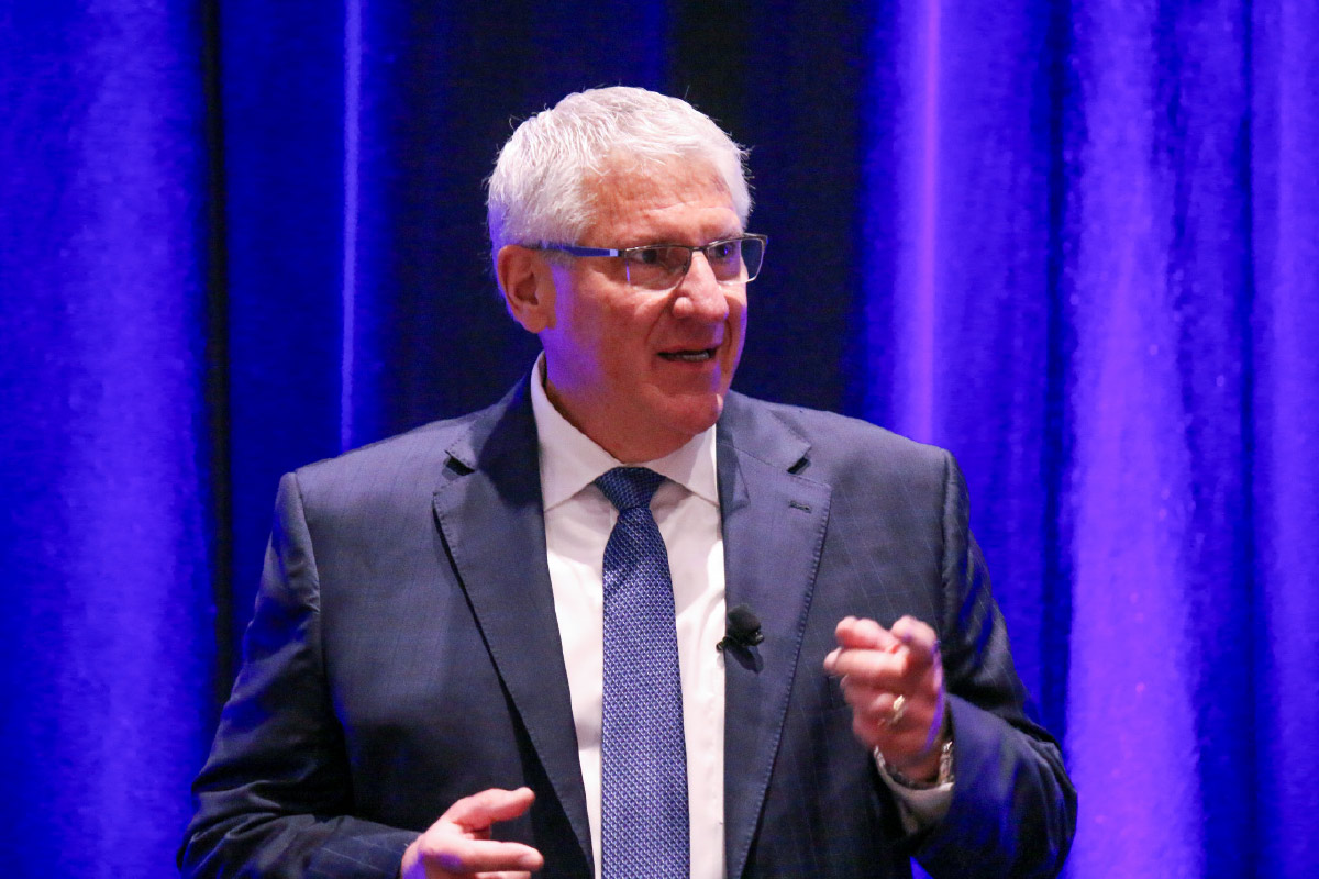 Peter DelGado giving a speech at a convention 