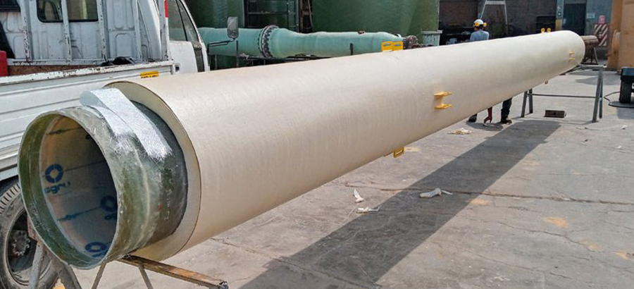 A long industrial dual-laminate pipe with a tan exterior and a translucent green interior liner, resting on metal supports in a workshop.